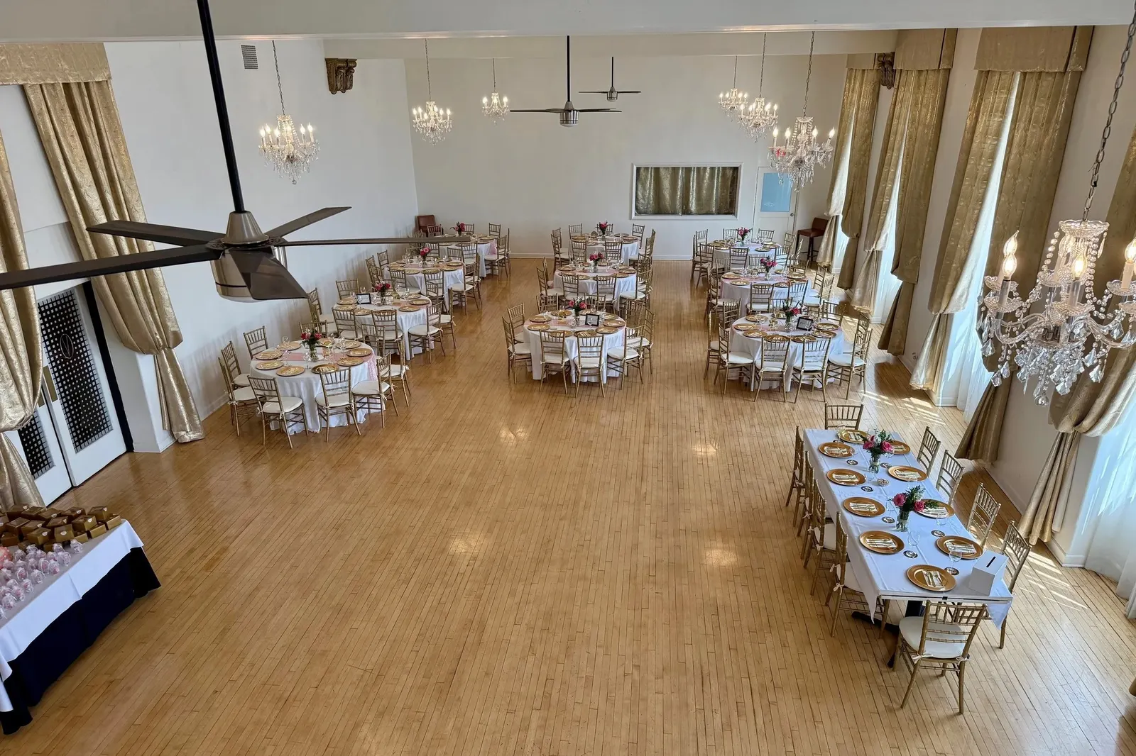 Sunset Room set for a dinner, gold drapes and hardwood floor